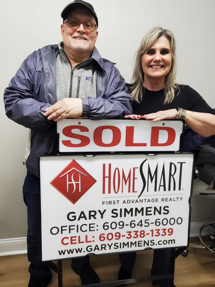 Gary Simmens clients with their HomeSmart First Advantage Realty sold sign